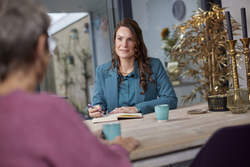 Marloes Verdonschot in gesprek met een nabestaande aan tafel